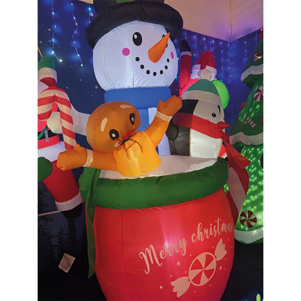 Boneco de neve insuflável num copo com um pinguim e um biscoito de gengibre_0